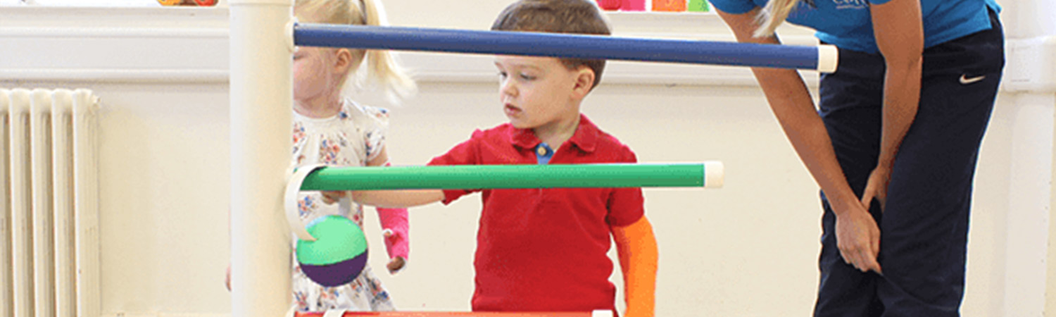 CIMT child patient sliding objects onto a pole.