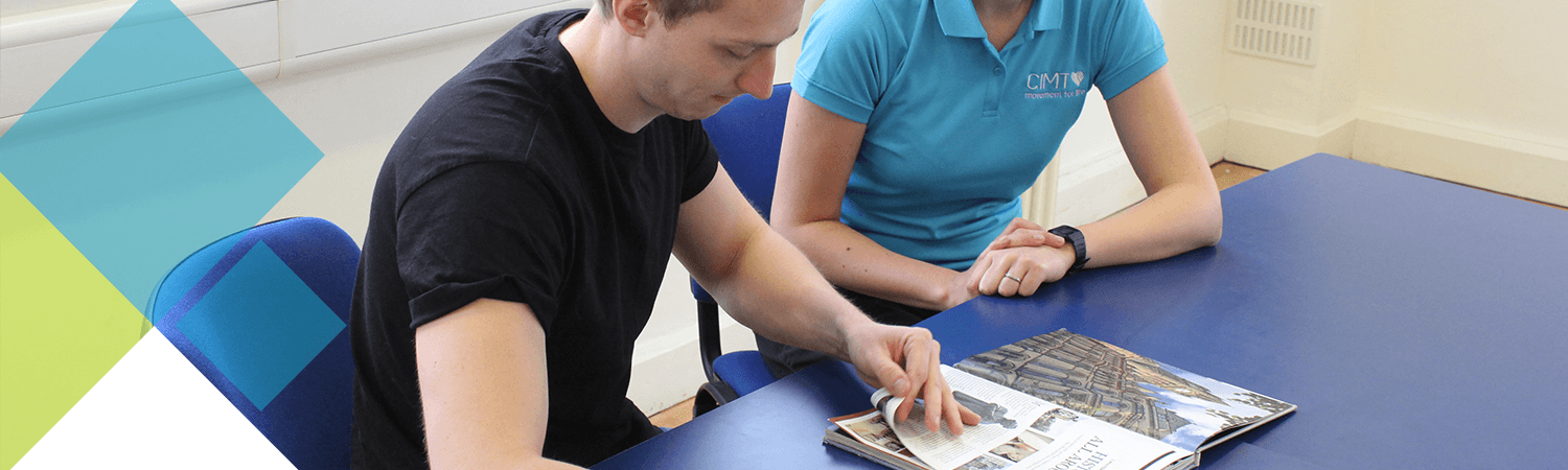 CIMT patient looks through magazine as part of his therapy CIMT patient looks through magazine as part of his therapy