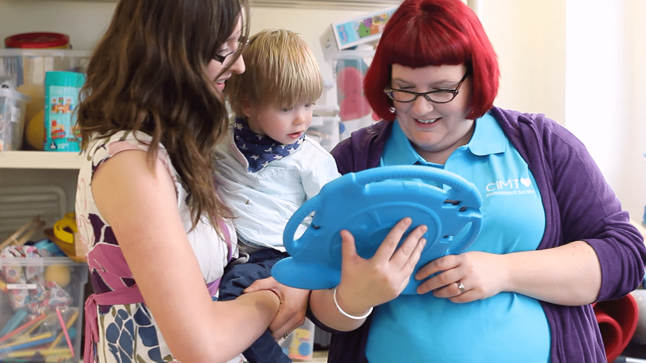 Alistair with his mum and therapist during CIMT treatment.