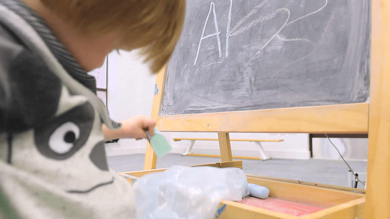 Alistair playing and drawing with chalk.