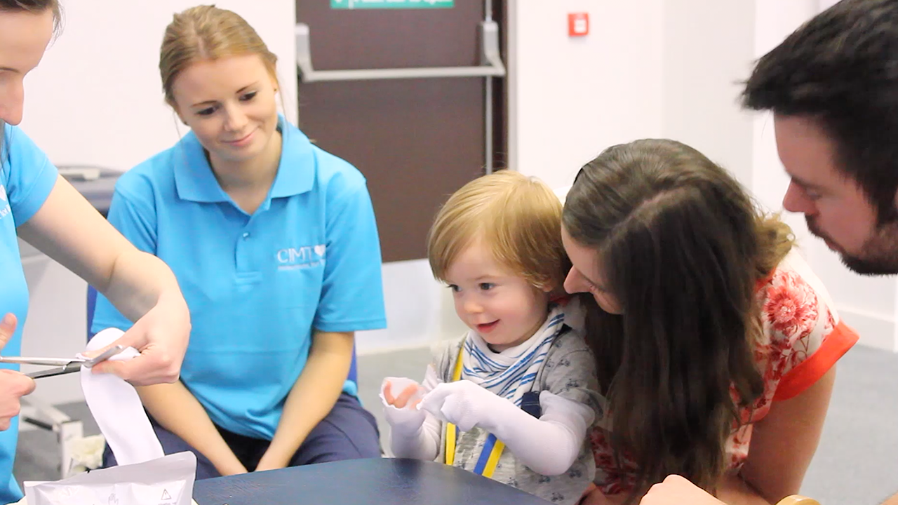 Alistair playing with his parents and therapists.