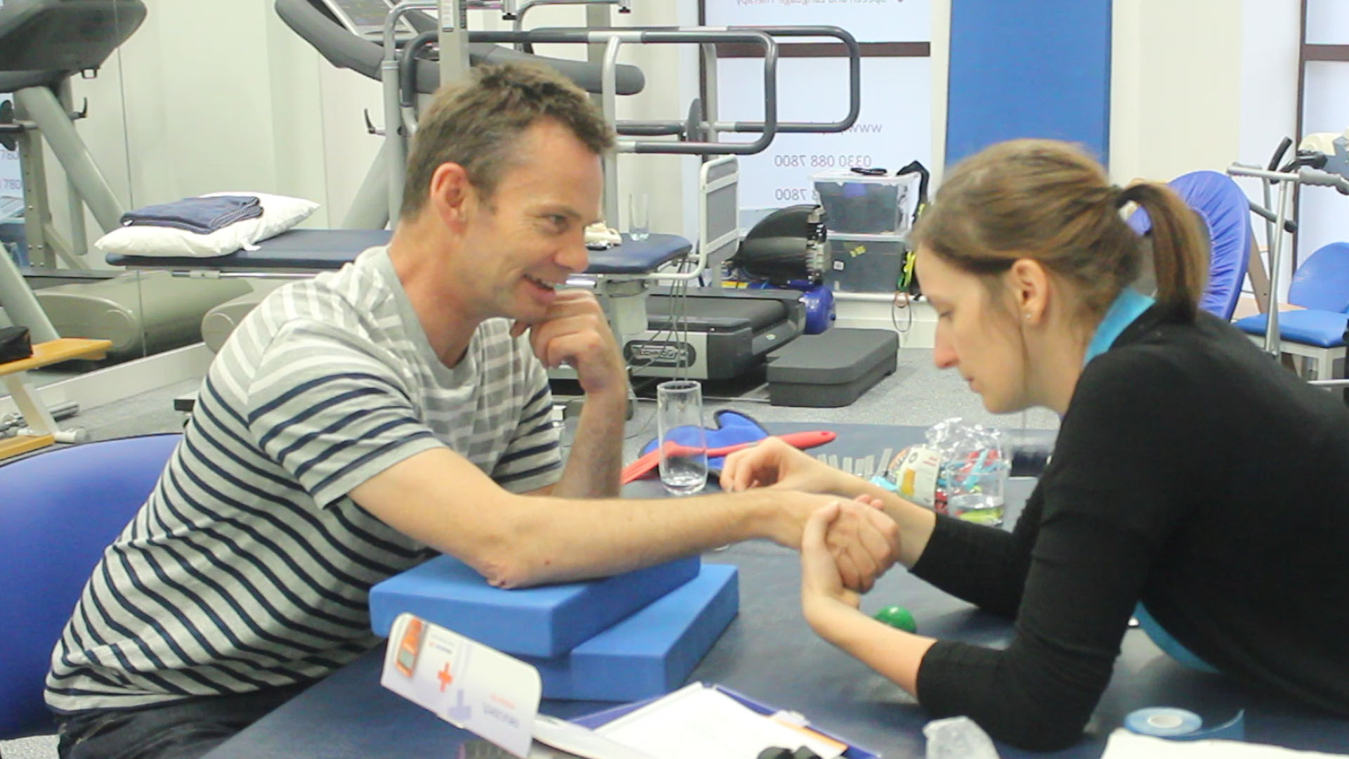 Andrew having his weaker arm examined by therapist.