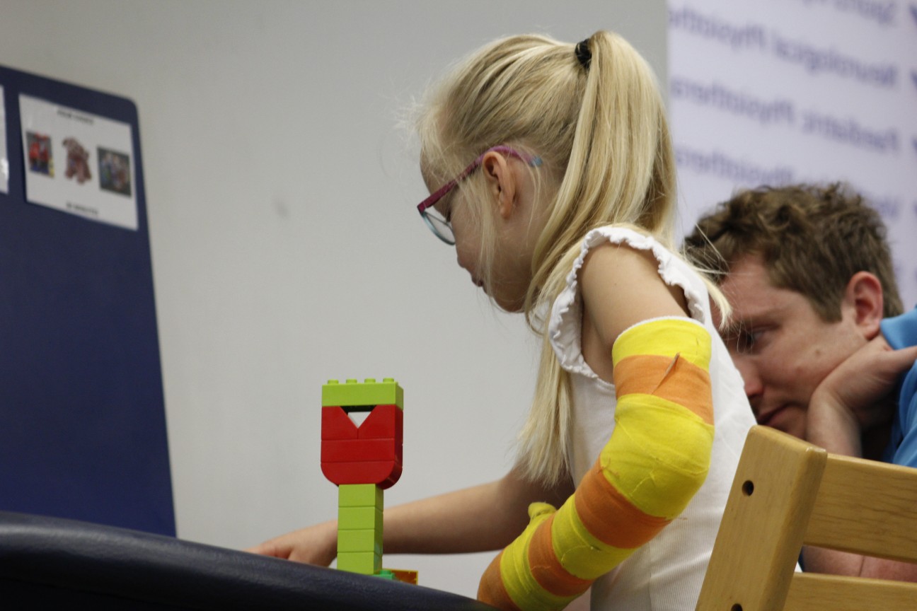 Darcie bieng shown how to use the toys during CIMT treatment