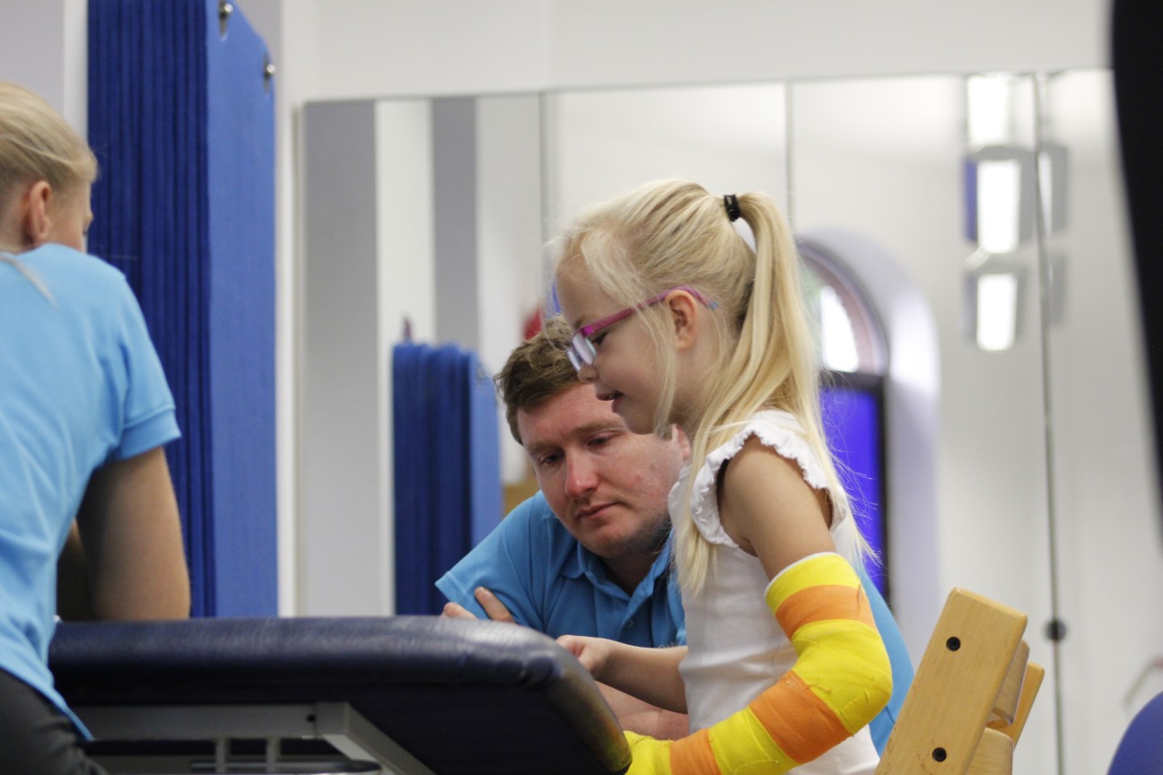 Darcie looking over at CIMT therapist during treatment.