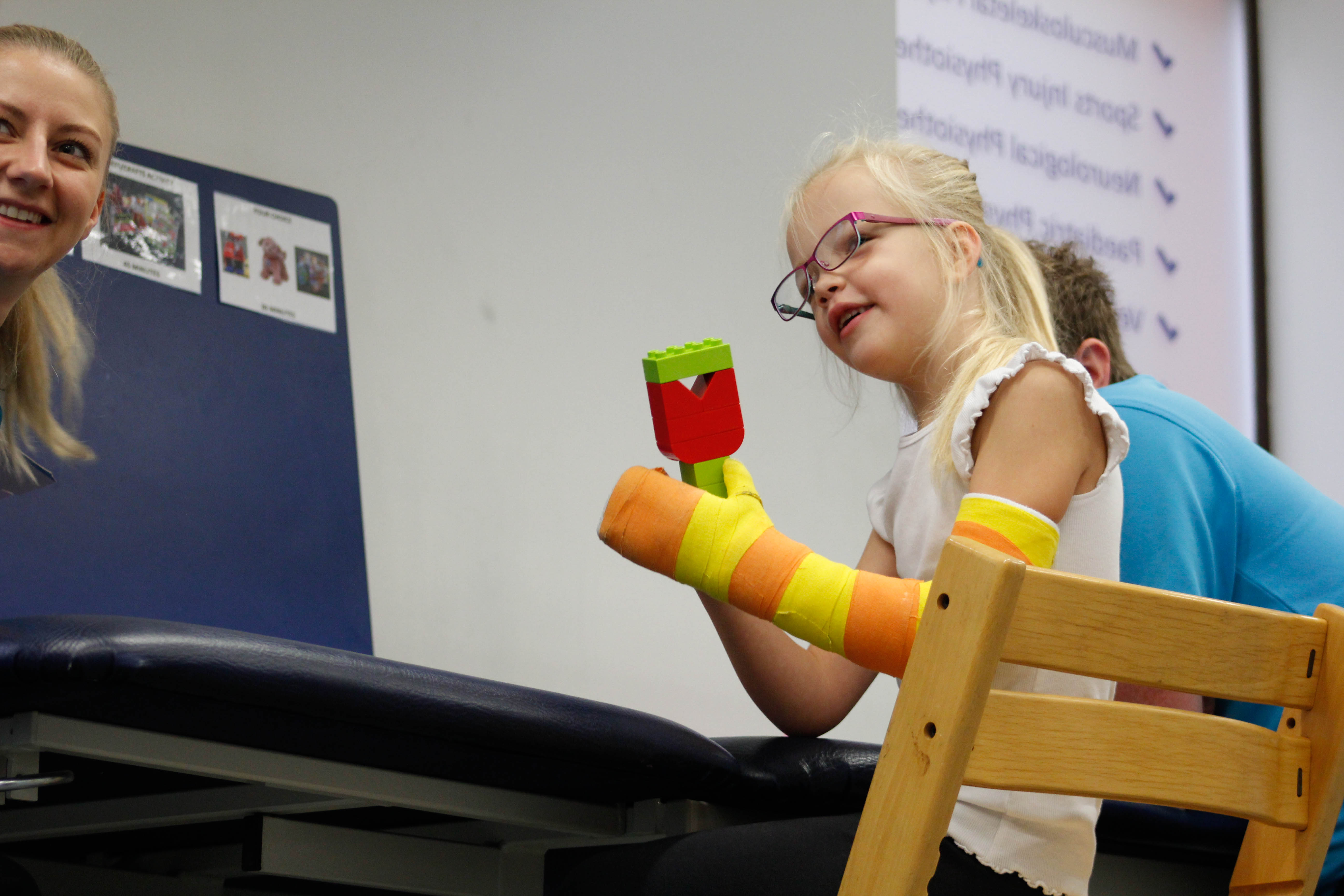 Darcie playing with a toy with CIMT therapists