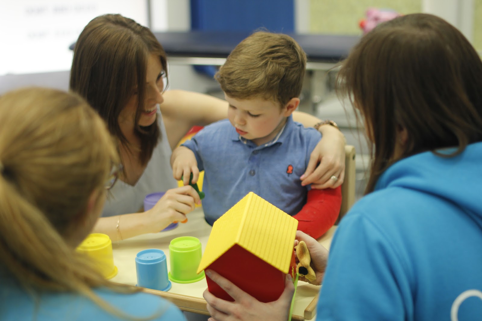 Finlay using his weaker hand to grab objects with guidance from parents.