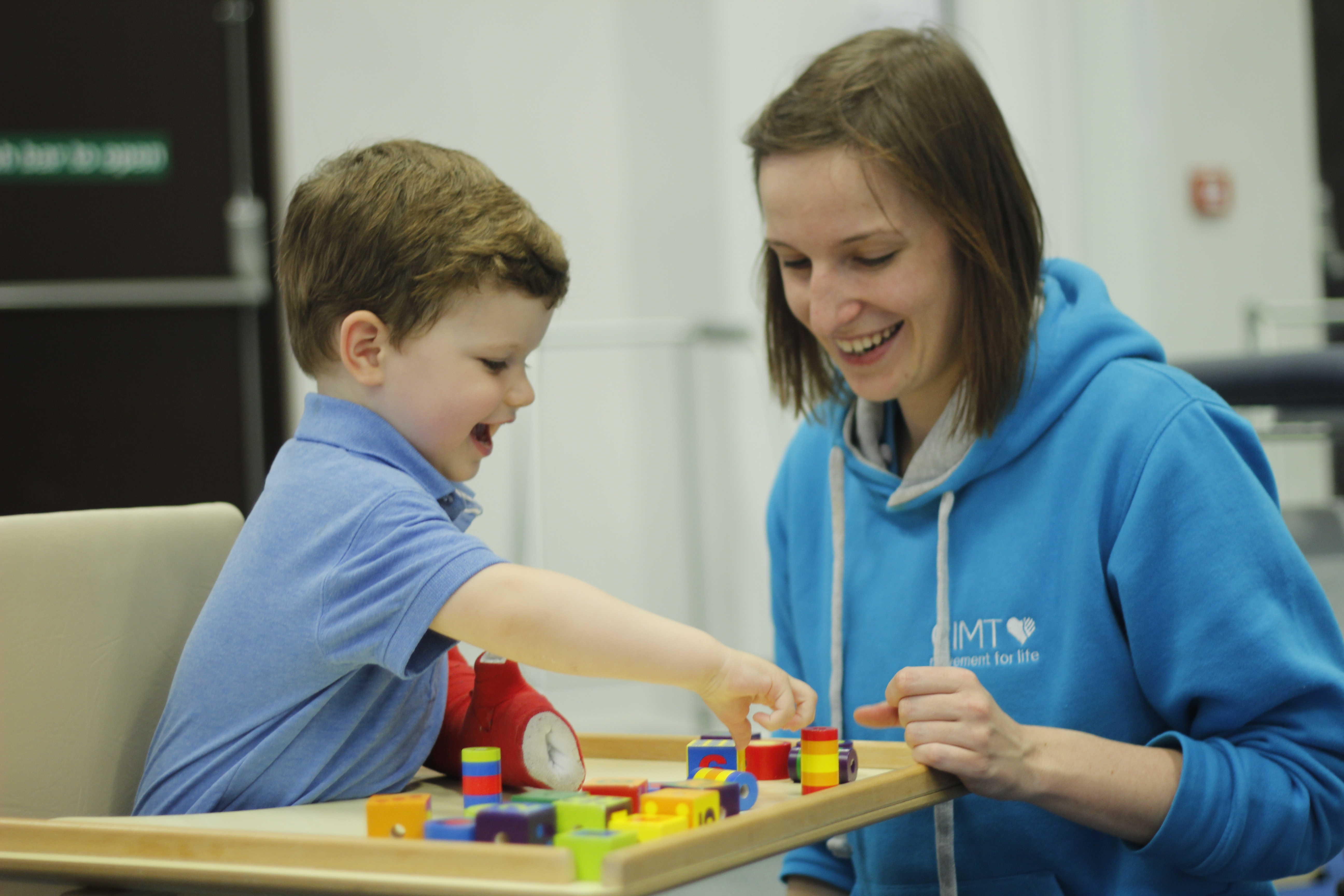 Finlay playing with small objects with CIMT therapist.