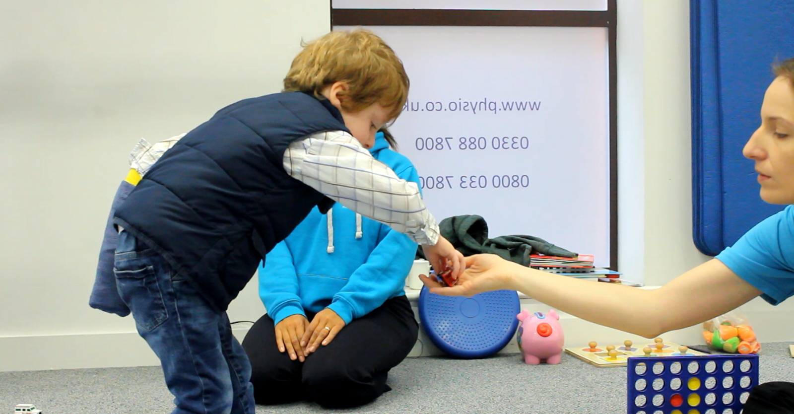 Freddie taking object from CIMT therapist's hand