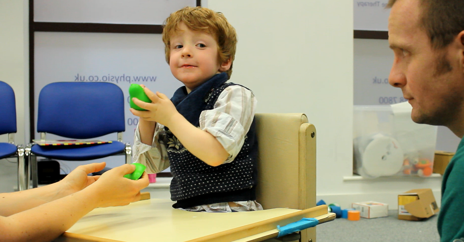 Freddie interacting with objects from CIMT therapists.