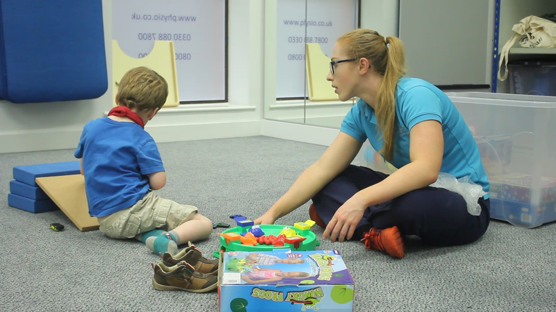 Freddie sat on floor working through games with CIMT therapist.