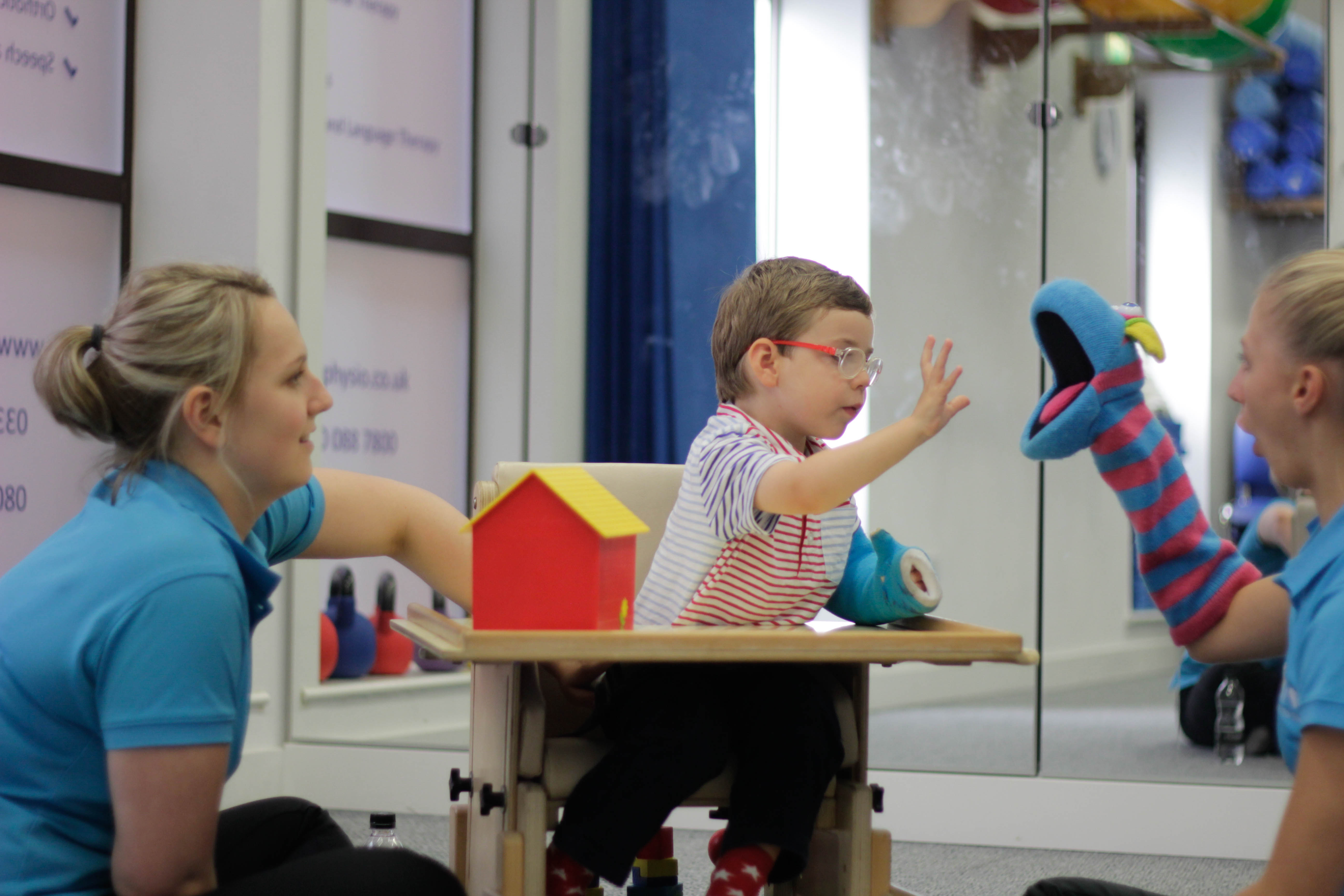 George playing with a toy with CIMT therapists