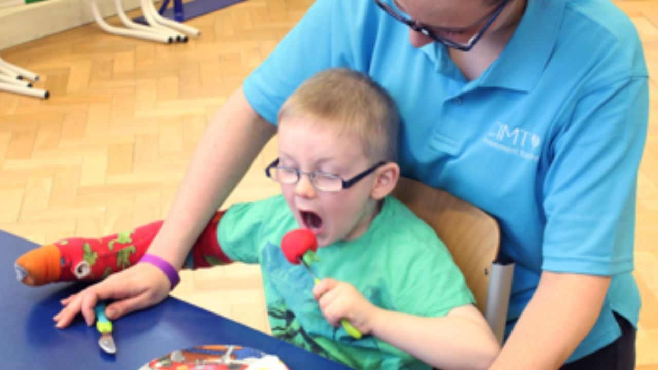 Harry practising with a knife and fork.