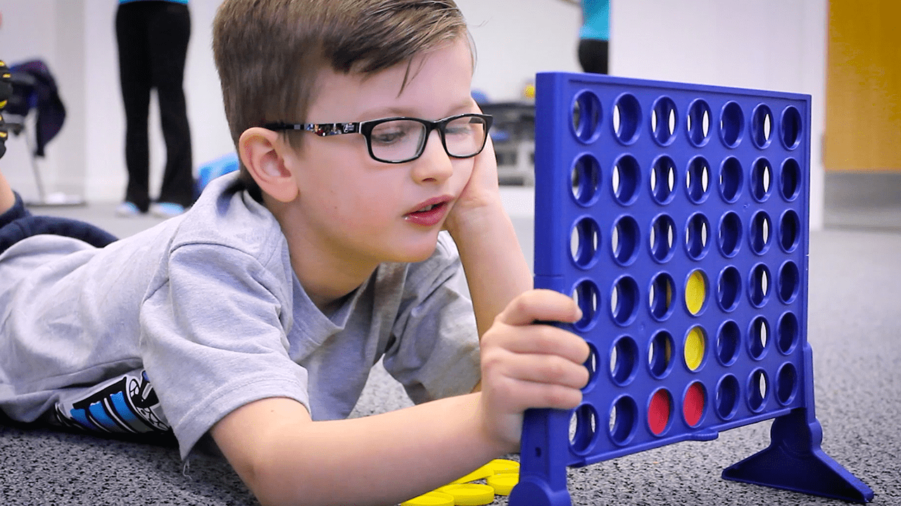 Jude playing Connect 4 on the floor.