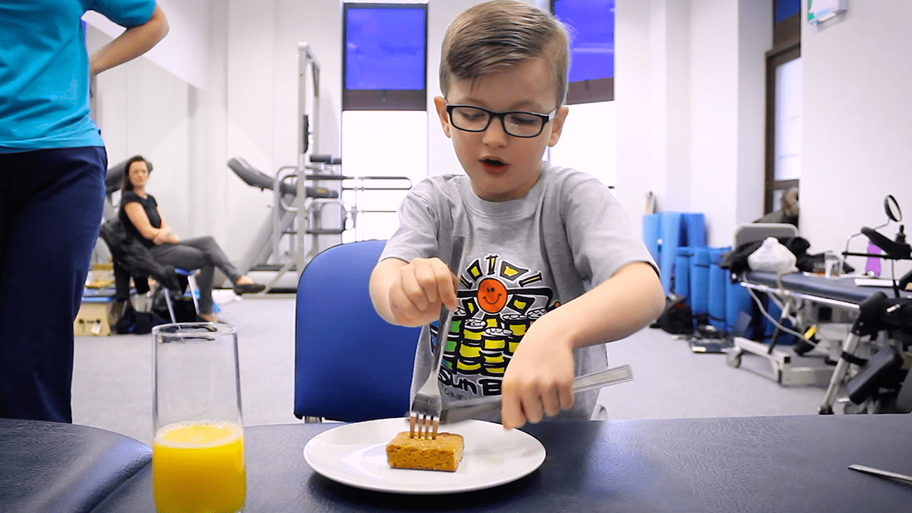 Jude practising using cutlery.