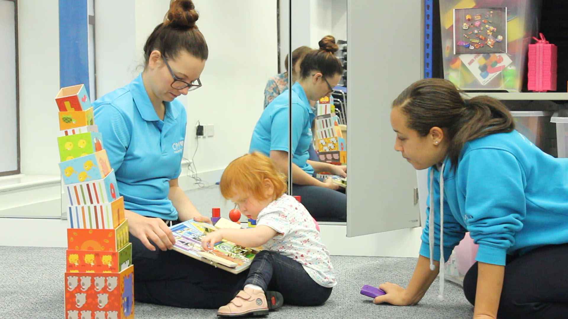 Kathryn playing with a puzzle set with help from therapist