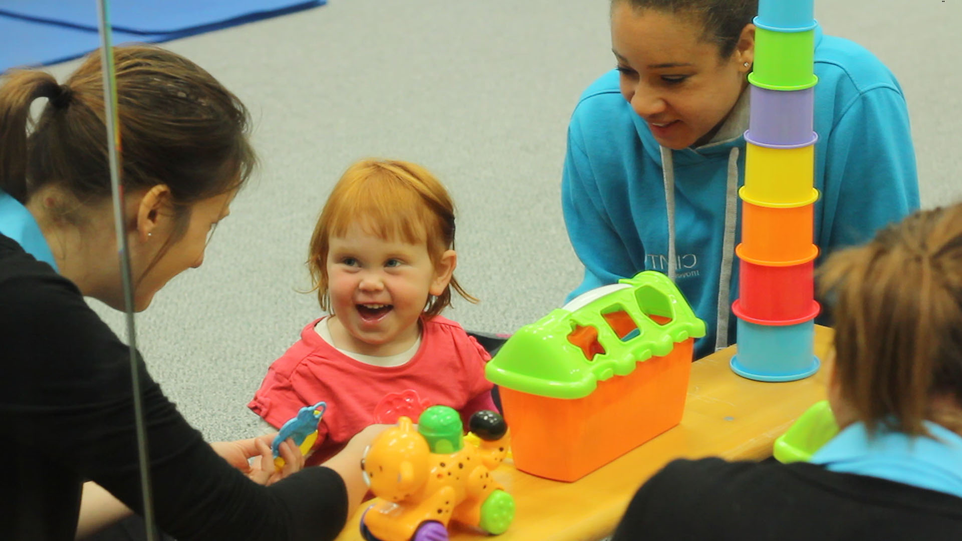 Kathryn playing with toy blocks with CIMT therapists