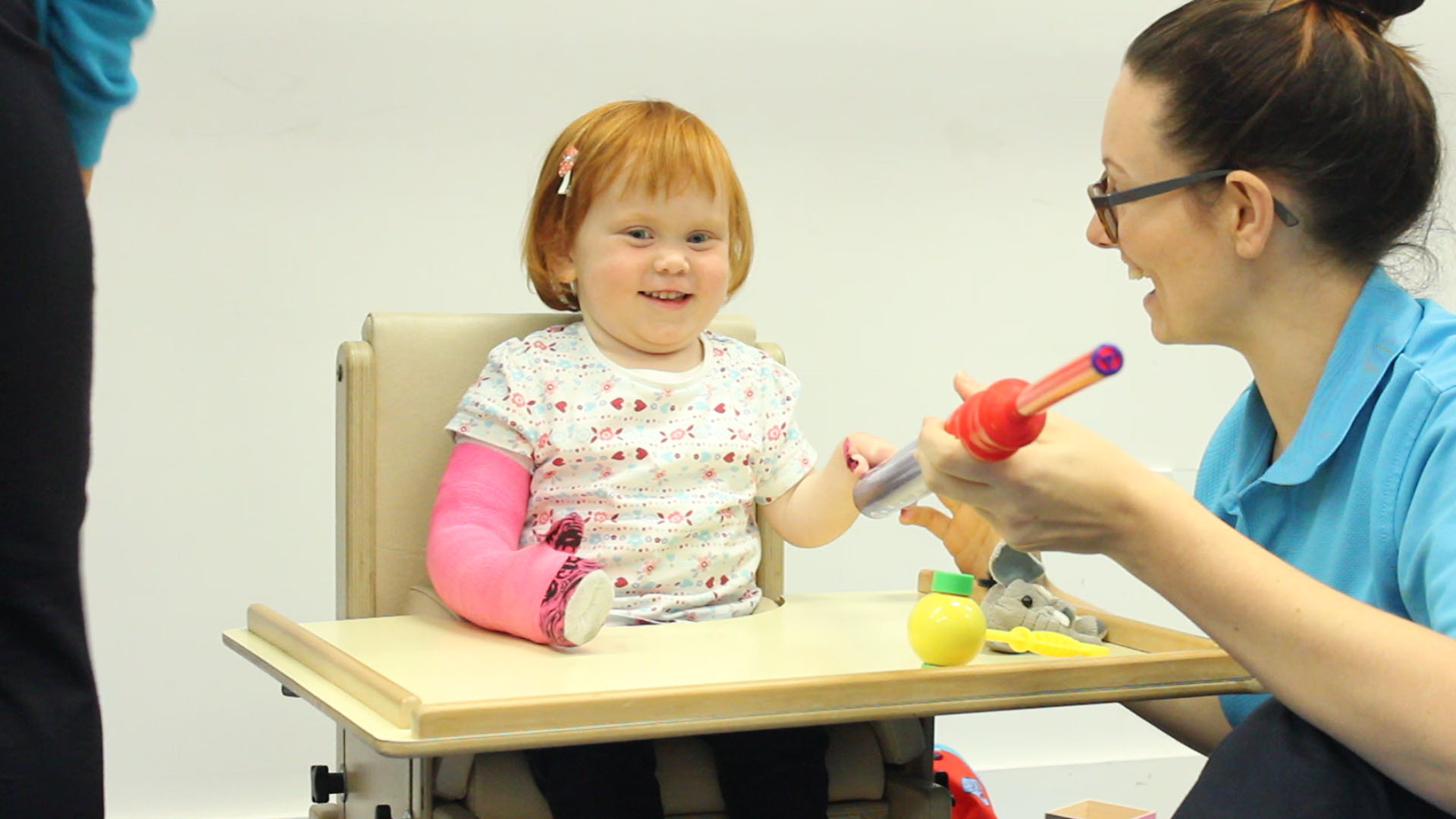 Kathryn playing with a toy rocket with CIMT therapist.