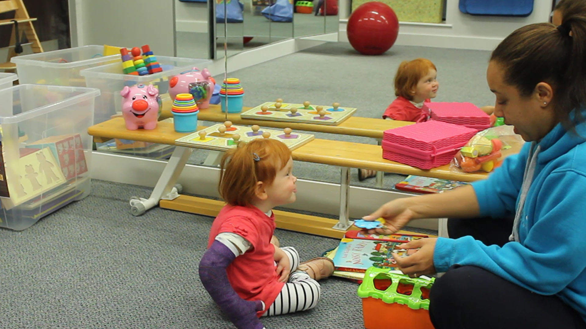 Kathryn playing on the floor with CIMT therapist.