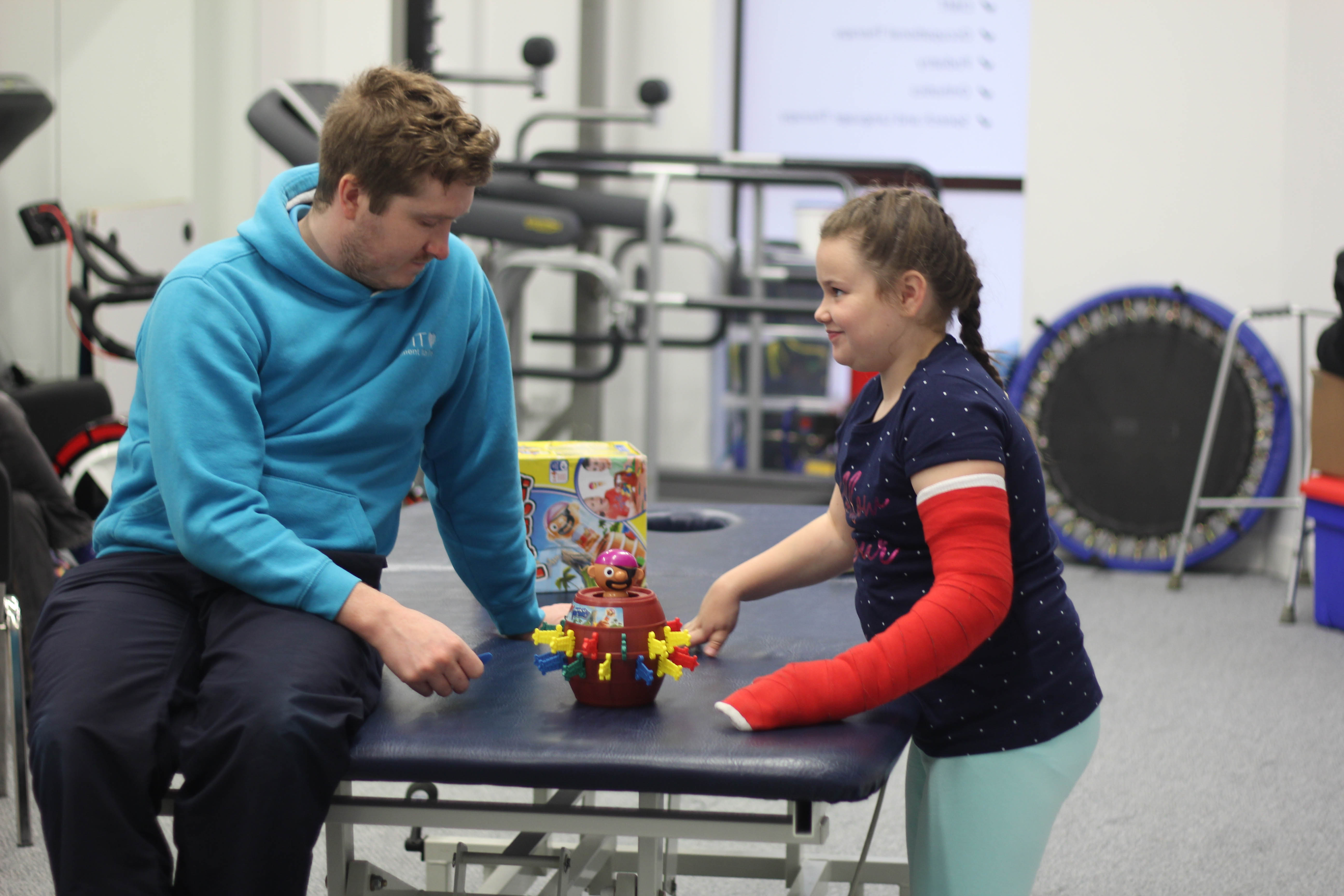 Katie looking over at CIMT therapist during treatment.