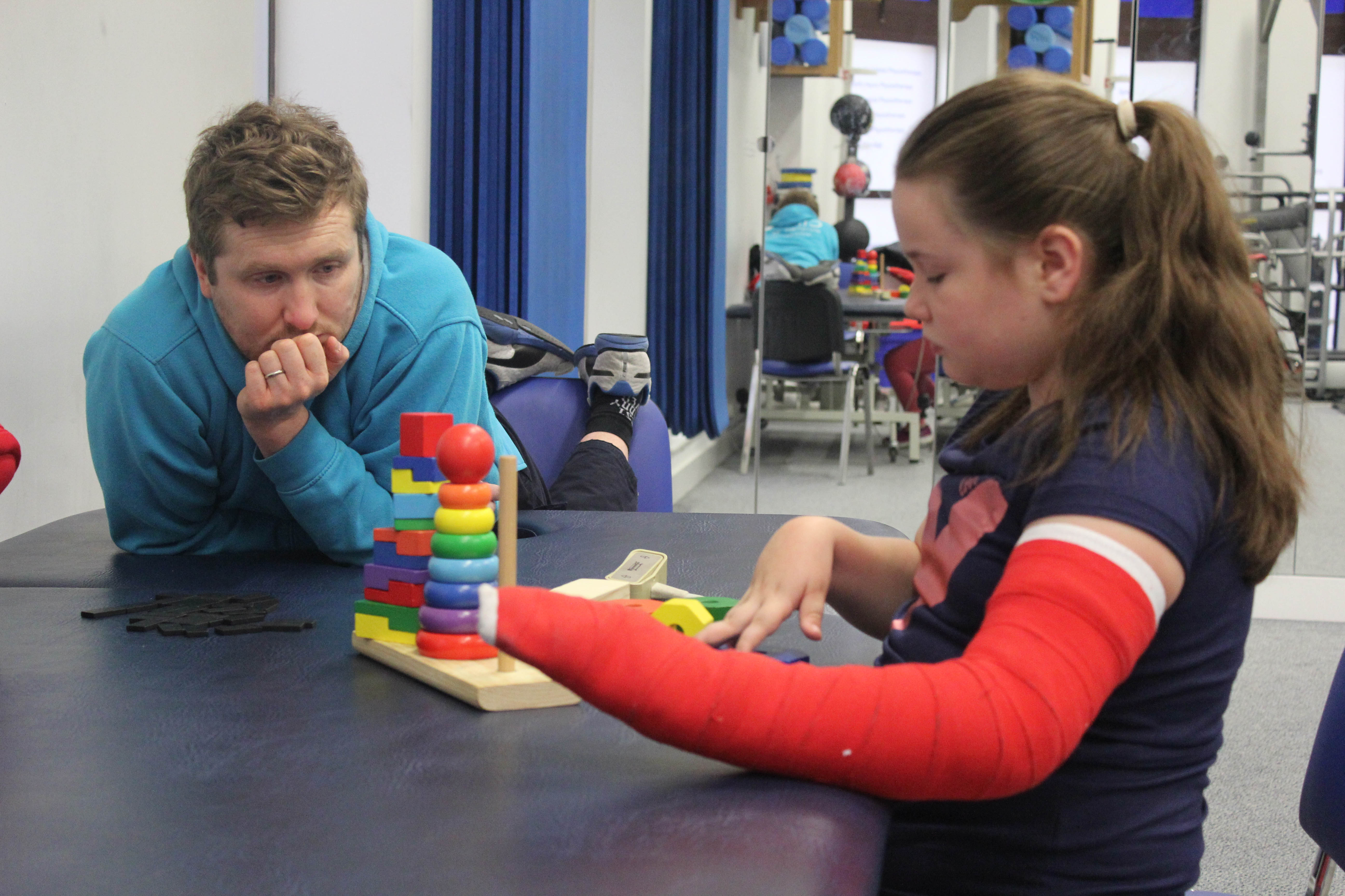 CIMT therapist Elliot observing progress with Katie.