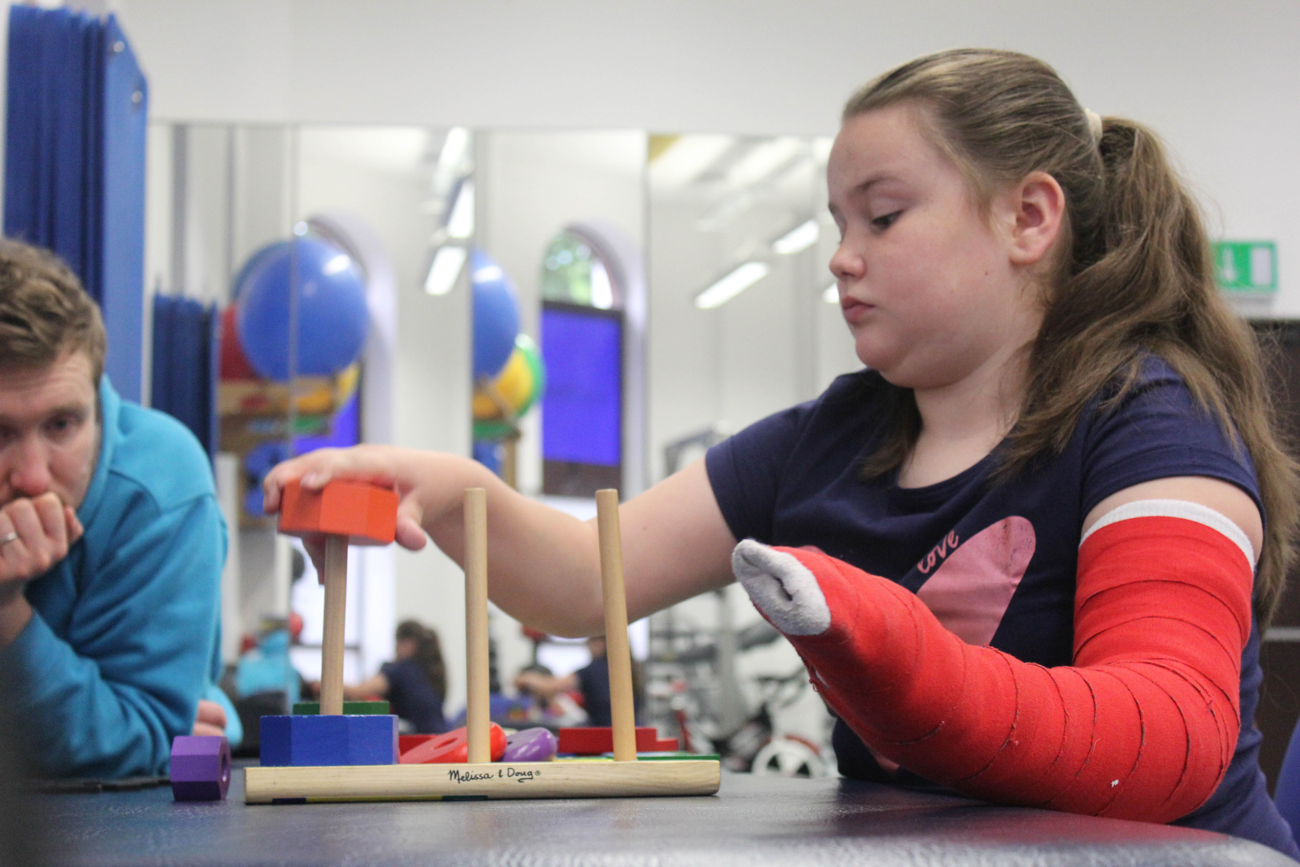 Katie picking up blocks using her weaker arm.