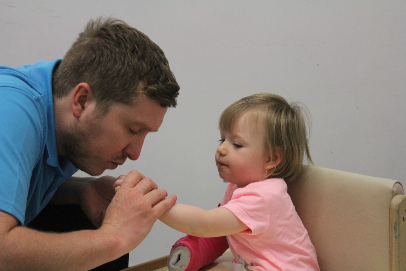 Leah guided by CIMT therapist during treatment.