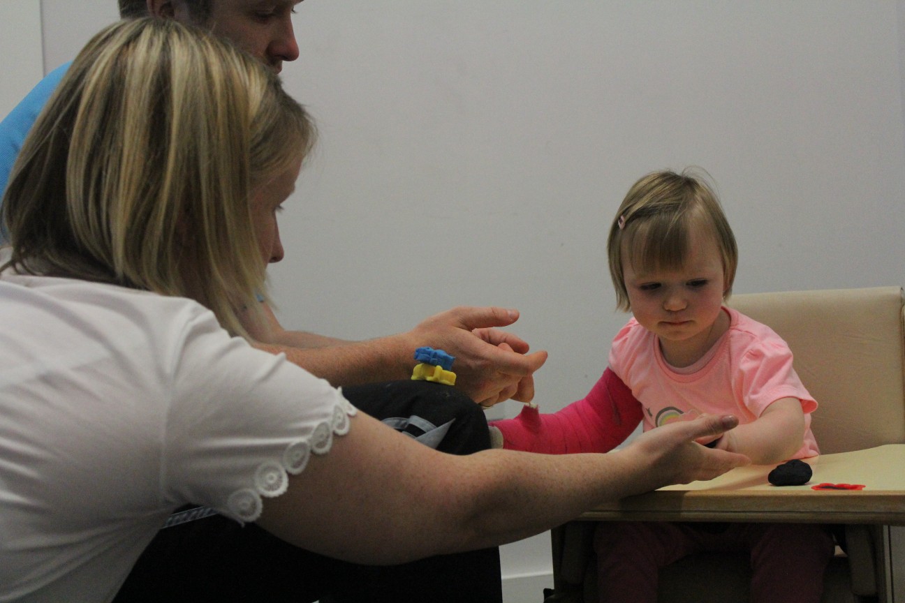 Leah looking over at CIMT therapist during treatment.