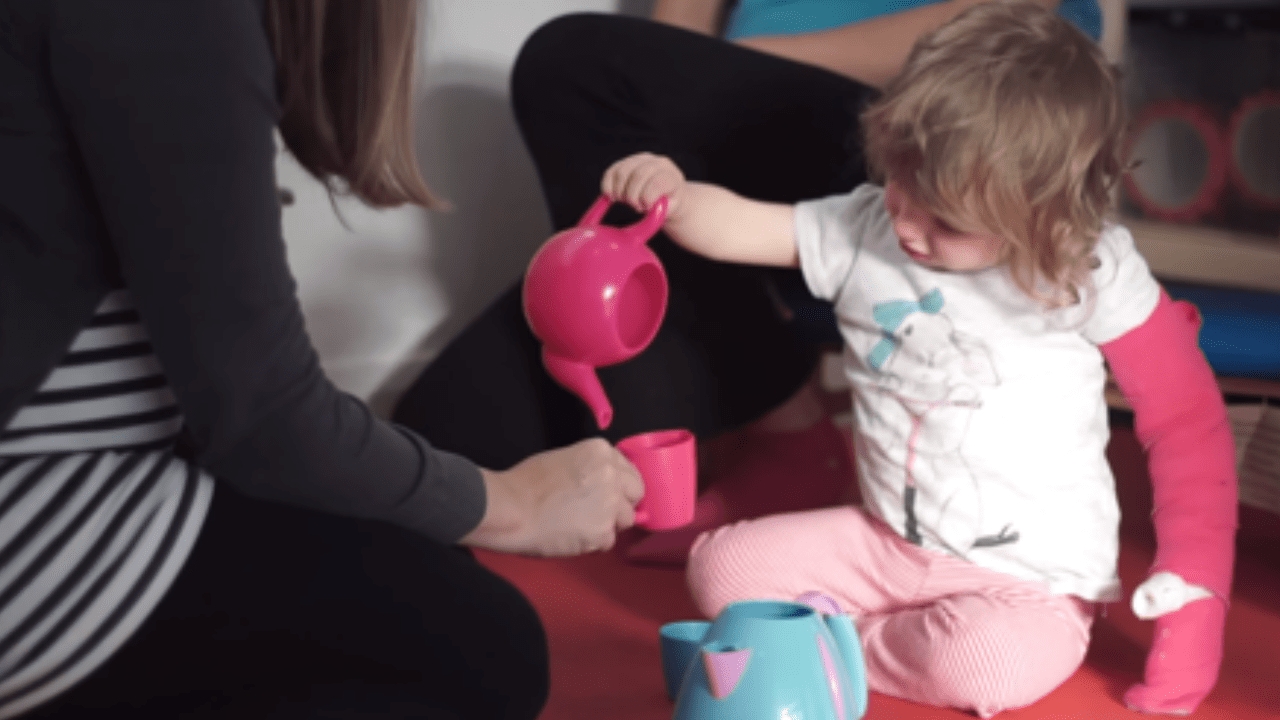 Lottie practising pouring tea.