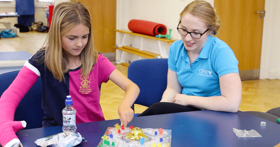 Lydia focusing on a board game with her therapist.