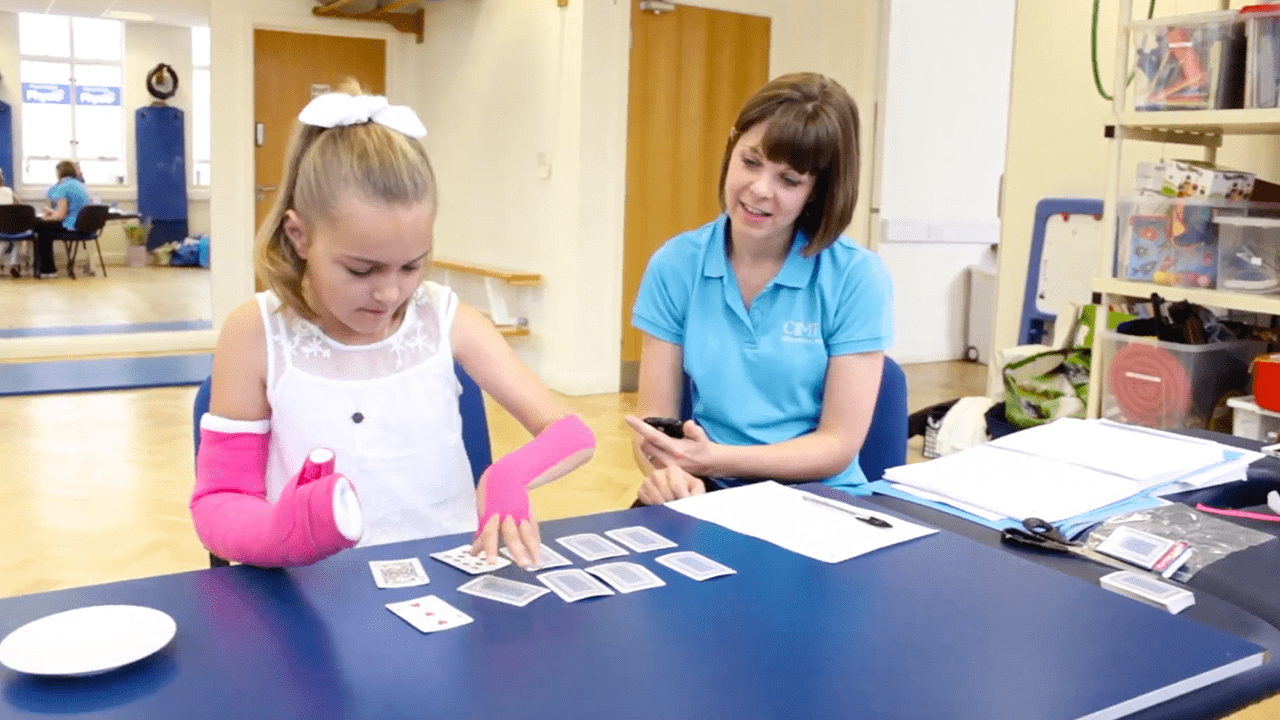 Lydia playing a card game with her therapist.