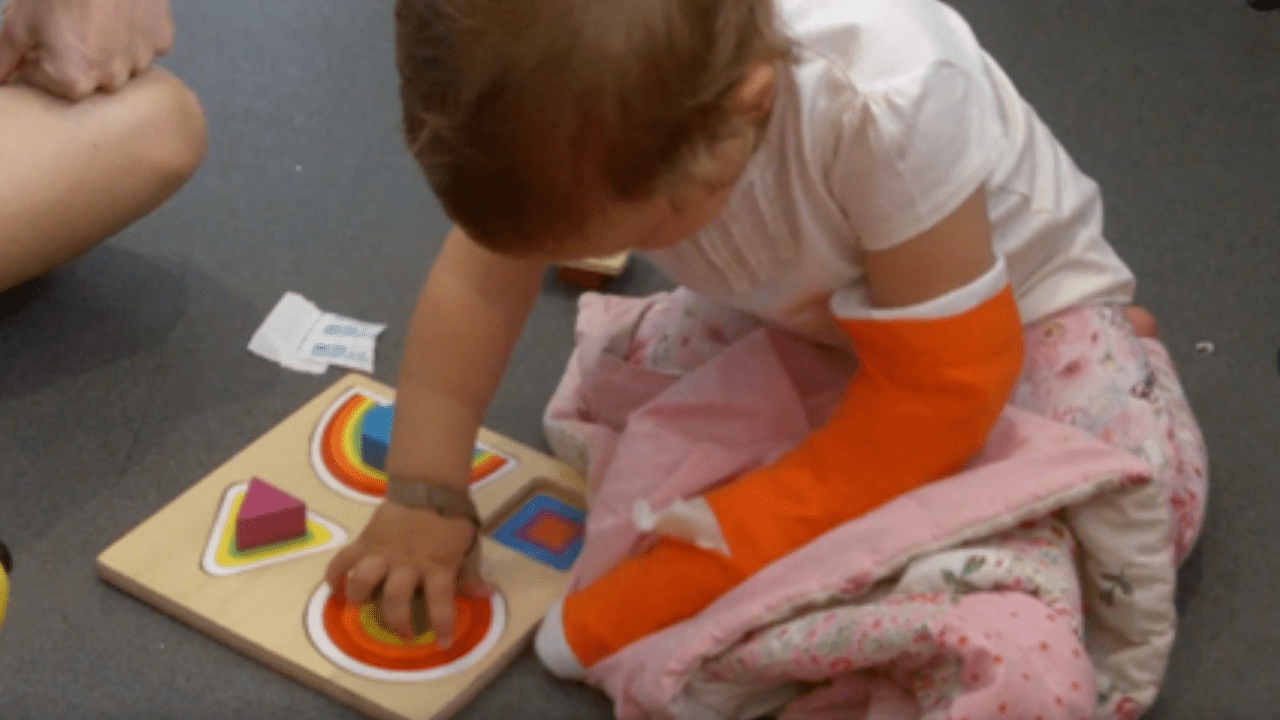 Molly with her cast on and playing with blocks.