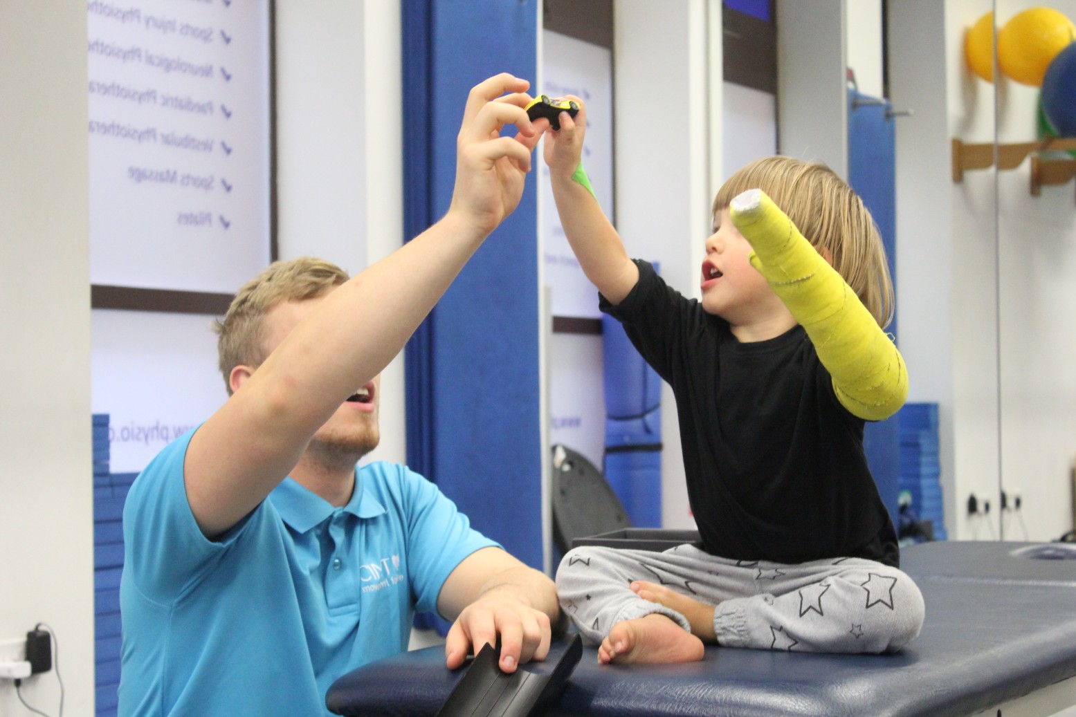 Reggie bieng shown how to use the toys during CIMT treatment