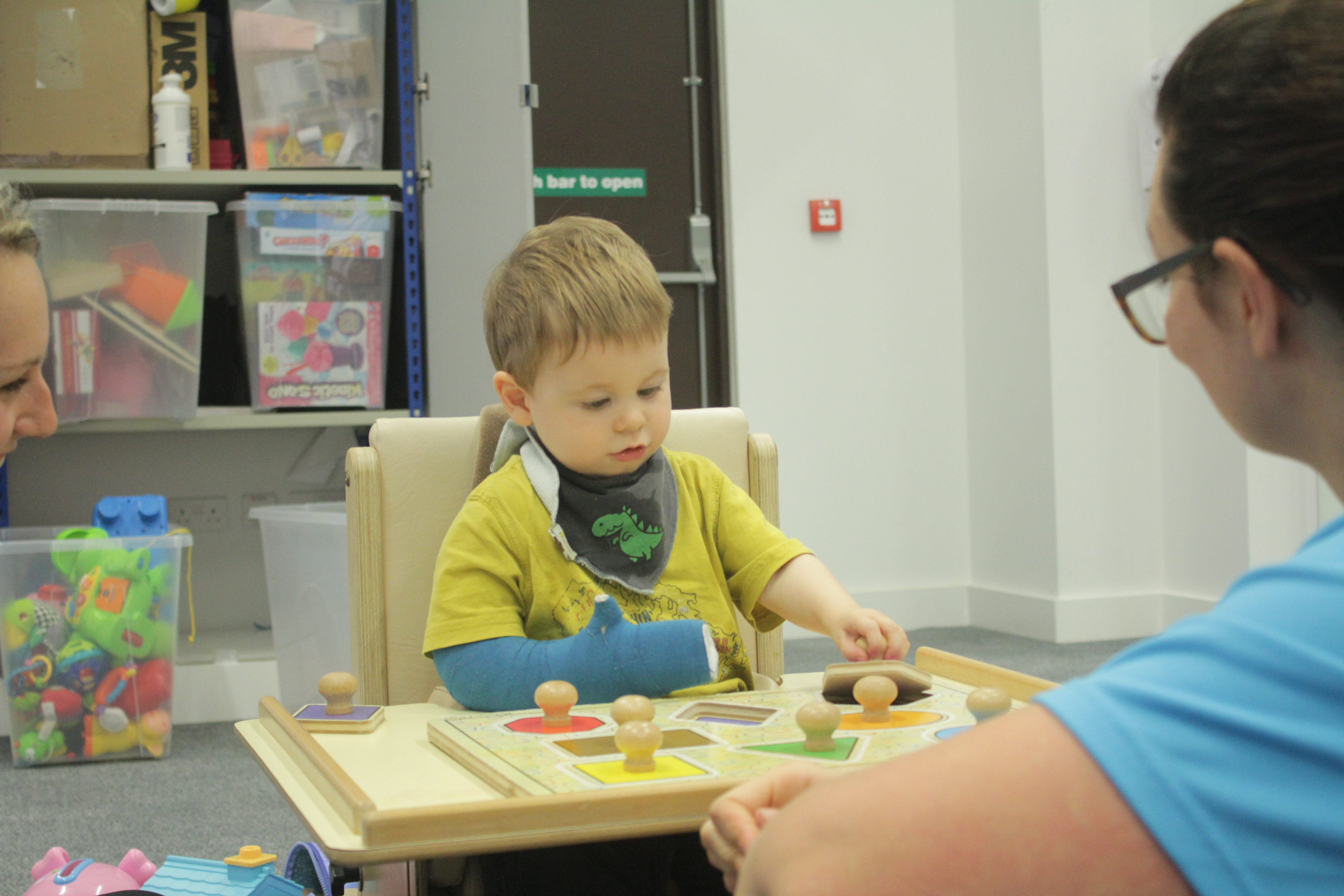 Thomas placing shape blocks in the corresponding holes using weaker arm