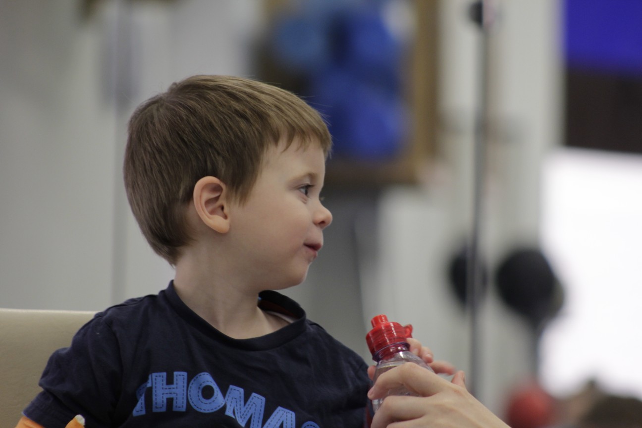 Thomas playing with a toy with CIMT therapists