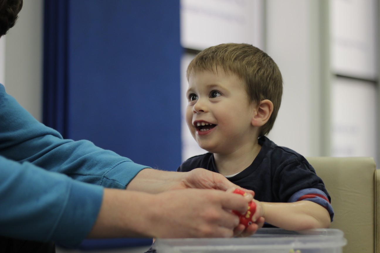 Thomas playing with shape blocks with CIMT therapists