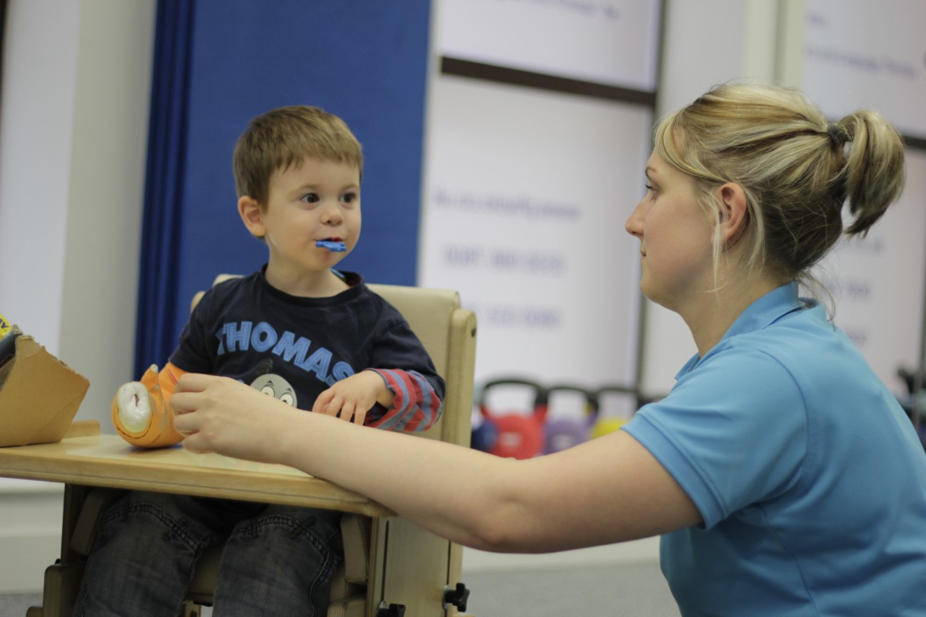 Thomas playing with toys with CIMT therapists.